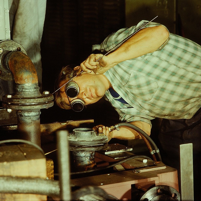 Ein Handwerker arbeitet präzise an einer Metallinstallation